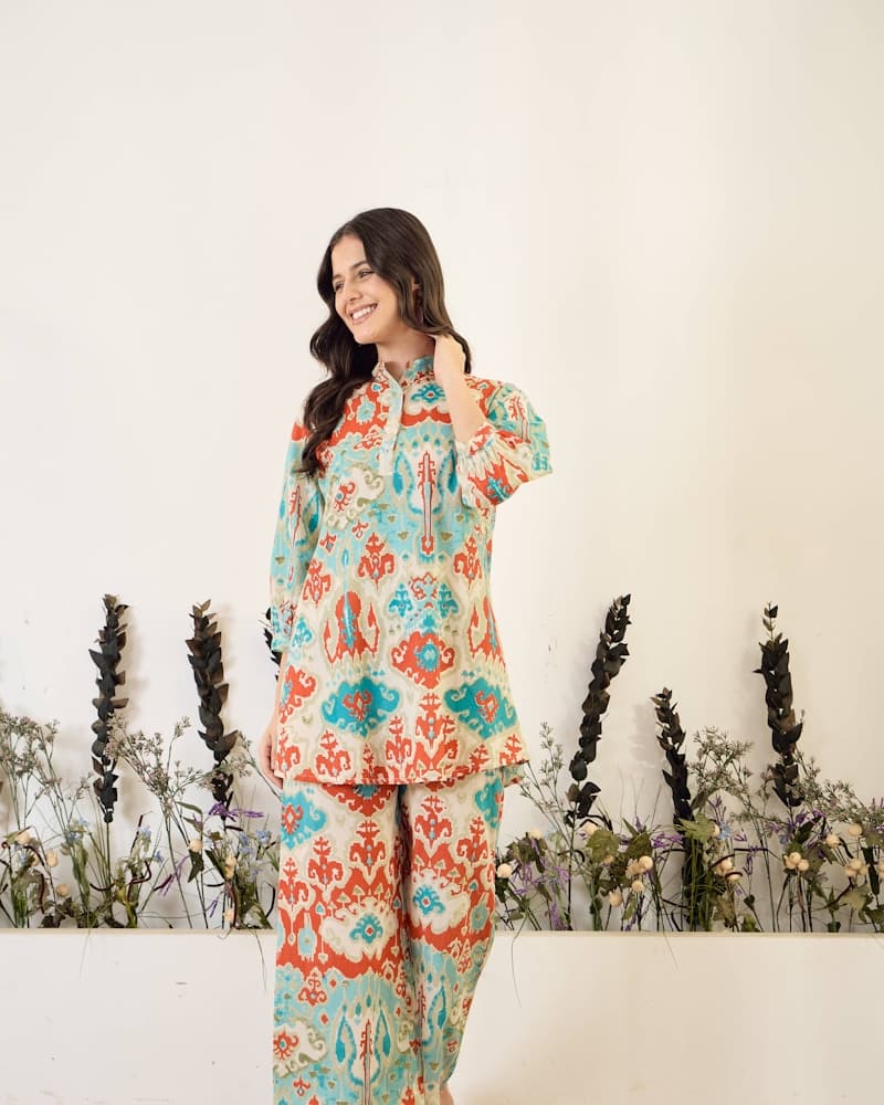 Woman seated outdoors in a deep rose mulmul kurti, detail crop