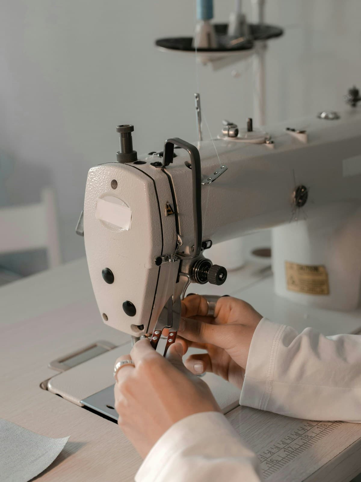 Hands guiding cloth through a sewing machine