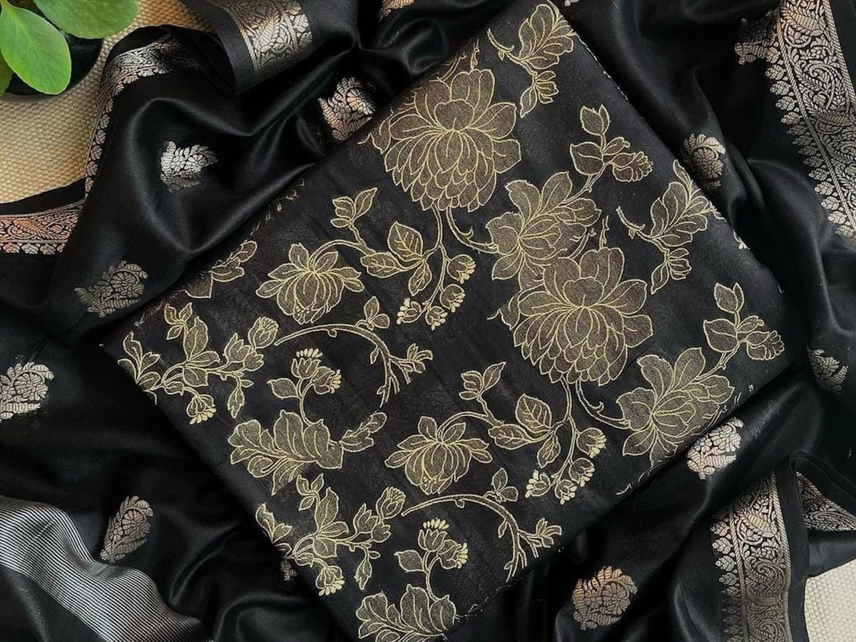 Black fabric with intricate floral embroidery and a silver border